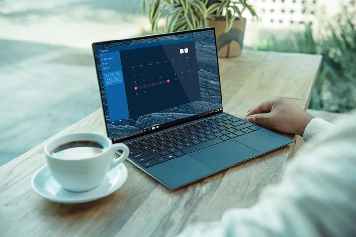 Notebook a šálek kávy na pracovním stole